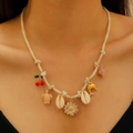 Detail of woven rope necklace with gold thread, featuring cherry, shell and sea life charms - KC Gold Cherry (3381)