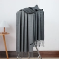 Detail of cashmere scarf with grey gradient fringe hanging on a metal rack - No.29 Light Grey