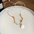Detalle de collar de cuentas hecho a mano con concha sobre plato de cerámica blanco - Collar de Concha de Cristal Blanco y Amarillo (5#项链-白色-黄色-水晶贝壳)