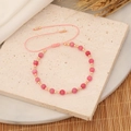 Détail du bracelet en perles roses avec accents dorés et cordon réglable - Rose