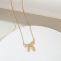 Détail du pendentif nœud doré avec zircons brillants et fine chaîne sur support - Double Boucle Nœud (Or)