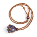 Detailed view of blue raw crystal stone secured in a brown hand-woven mesh net pendant - Lapis Lazuli