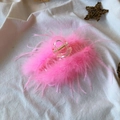 Detail of pink ostrich feather hair claw clip on beige fabric with decorative stars - 13CM Pink Feather Claw Clip