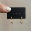 Primer plano de pendientes de corazón dorados con circonitas en tarjeta de joyería - Blanco/Dorado / Poste de Pendiente