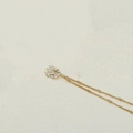 Elegant gold pearl necklace with a minimalist round pendant on a textured background - Letter Q