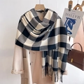 Detail view of black and white plaid scarf with fringe and fashion label on a hanger - Large Plaid Black and White