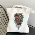 Vintage canvas tote bag with skull floral print on black metal chair for travel - Red Green Floral Skull