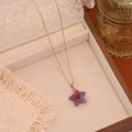 Close-up of a purple star natural stone pendant necklace on a wooden display stand - Amethyst (No.3)