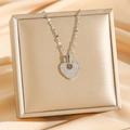 Collar con colgante de corazón plateado con pedrería sobre un joyero de terciopelo - Corazón Plateado (8426)