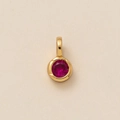 Gold pendant featuring a round red zircon stone set on a textured beige background - Round July Pendant (Dark Red)