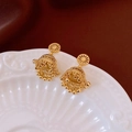 Détail des boucles d'oreilles cloche plaquées or 14 carats avec motifs ajourés sur plateau - Doré
