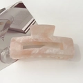 Close-up of pink marble pattern acetate hair claw clip with shimmering glitter finish - 10.5cm Rectangular / Starry Orange