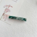 Detalle de pinza para el cabello en acetato jaspeado sobre tarjeta floral - Verde Lago