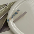 Detalle de pinzas de acetato en azul marmoleado y gris sobre un plato blanco - Morado Corto Juego de 2
