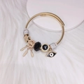 Gouden bedelarmband met dromenvanger en evil eye hangers op wit imitatiebont - Zwart