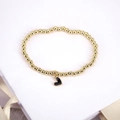 Golden beaded bracelet with a black enamel heart charm on a white gift box - Black