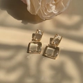 Orecchini geometrici dorati vintage con cristalli trasparenti sotto luce naturale soffusa - Oro Trasparente