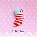 Detail view of a 1.9x2.2cm Christmas stocking resin charm with red stripes and blue cuff - Heart Christmas Sock - Red