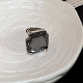 Macro shot of large square dark grey crystal with vintage silver claw setting - Black