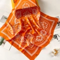 Close-up of bright orange paisley silk scarf with satin finish and floral detail texture - 70*70cm / Orange