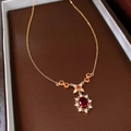 Detailed macro of gold-plated necklace featuring a red gemstone pendant in a gift box - 20# Gold Red Gemstone Necklace