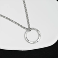 Gros plan du collier en acier titane argenté avec pendentif anneau texturé et gravure ROAD - Mobius