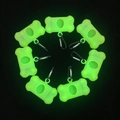 Eight green bone-shaped dog poop bag dispensers with black carabiners on black background - Luminous