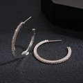 Macro shot of silver C-shaped hoop earrings with sparkling cubic zirconia on dark background - Hoop Earrings-Silver-3cm