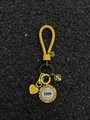 Détail d'un porte-clés en cuir tressé jaune avec jeton de poker et breloque coeur - Style Jeton en Corde de Cuir Jaune