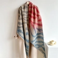 Écharpe à motif zèbre avec franges, élégamment drapée sur un manteau beige minimaliste - Zèbre Beige Rouge Bleu