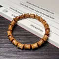 Bracelet en bois à 18 perles en forme de fuseau sur un livre de calligraphie vintage - Santal Vert 8x10mm Forme de Bambou