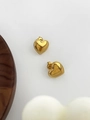 Macro shot of gold heart earrings with beaded edge and polished stainless steel texture - Heart Stud Earrings