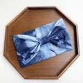 Blue tie-dye wide yoga headband with bow design on a rustic wooden octagonal tray - Blue Tie Dye