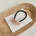 Detailed macro view of a pink acetate hair ring with gold lettering on a white card - Pink Striped