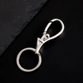 Nahaufnahme des polierten Edelstahl-Schlüsselanhängers mit Karabiner auf dunklem Stein - Silberne Unregelmäßige Schnalle (E619)