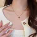 Close-up of a gold necklace with a round tiger eye stone pendant on a white cardigan - 13# Necklace - Gold (Exquisite Round Pendant Style)