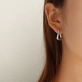 Orecchini a perno geometrici a triangolo in argento indossati da una modella reale - Orecchini Geometrici a Triangolo Irregolare / Color Acciaio
