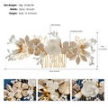Detalle de peineta para novia con hojas doradas, flores blancas y perlas elegantes - Dorado