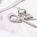 Detail view of large silver metal hair claw with pearls and heart-shaped handle design - Silver Bow Pearl Style