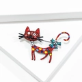 Dettaglio della spilla a gatto rosso con pois colorati, collana di perle e fiocco blu - Gatto Divertente - Rosso