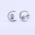 Macro detail of moon and star earrings with sparkling zircon stones and blue center gem - Single Crescent Moon