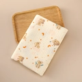 Close-up of cotton muslin baby swaddle with koala and star patterns on wooden tray - 100x100cm / Little Koala