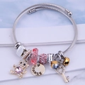 Adjustable stainless steel wire bracelet with pearl bear, pink crystals and charms - Pink
