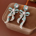 Detailed shot of vintage bow earrings with turquoise beads and pink crystals on velvet - Blue/Pink