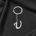 Polished silver stainless steel letter V keychain on black silk background - Letter U