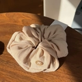 Detail of cream scrunchie with linen texture and amber oval bow emblem on wood - Light Khaki Bowknot Button Scrunchie