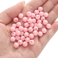 Pink matte acrylic round beads for DIY jewelry making being held in hand - Deep Pink