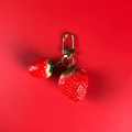 Porte-clés fraise rouge mignon avec feuilles vertes sur fond rouge éclatant - Double Fraise + Fermoir