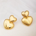 Macro detail of puffy double heart gold stud earrings with a polished mirror finish - Double Heart
