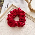 Detail of red wrinkled fabric scrunchie on vintage book page with white frame - Glossy Red